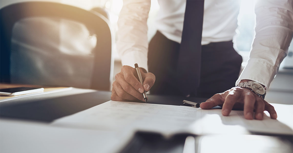 a business man signing a document